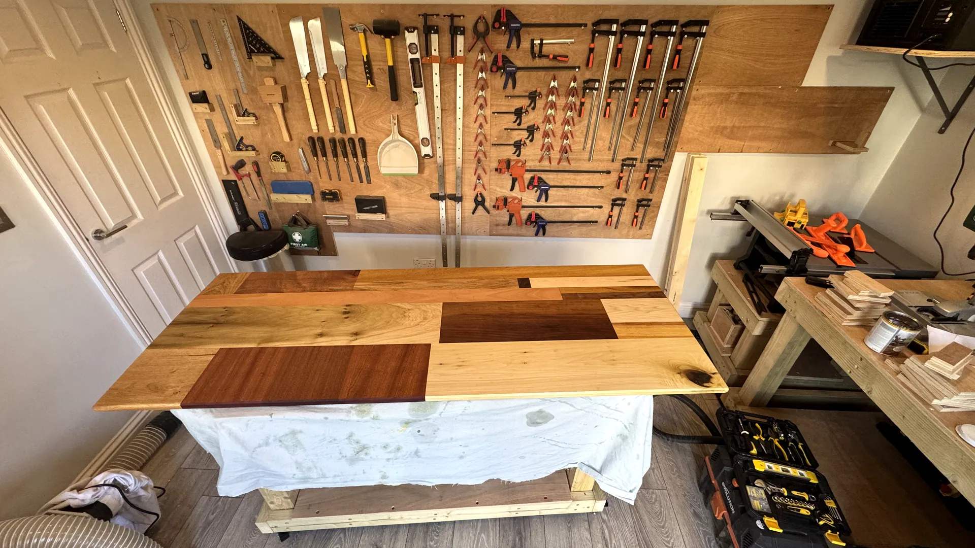 The workbench with timber laid out and the tool wall behind