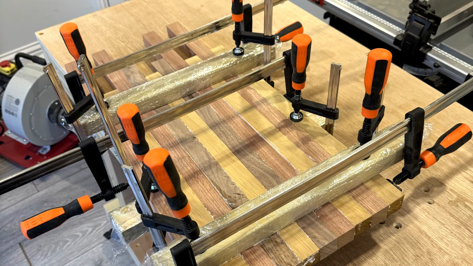A chopping board glue-up held in clamps on the bench